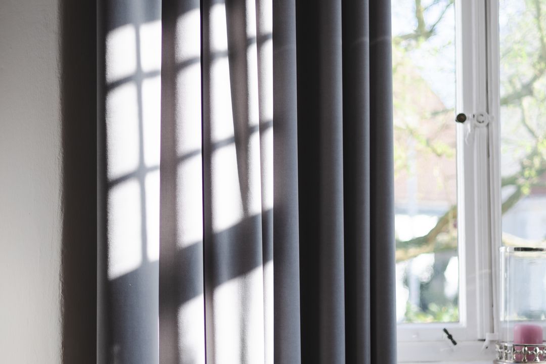 Open window with curtains and daylight entering a home