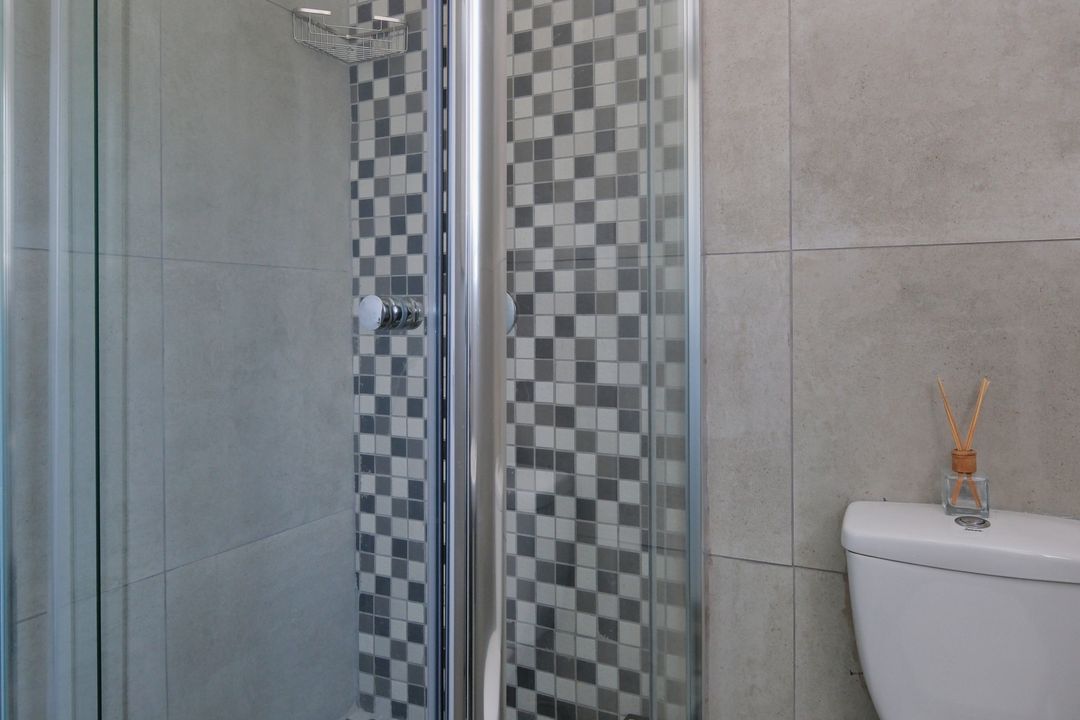 Glass shower enclosure surrounded by bathroom tile